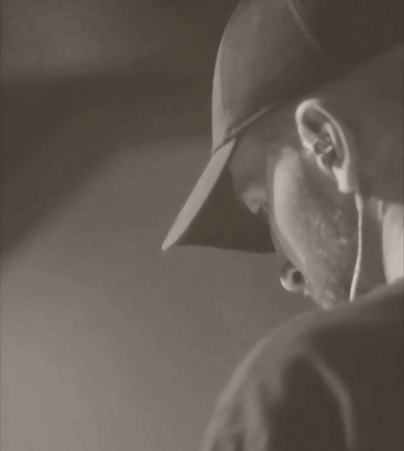 Rexonate wearing headphones in the booth